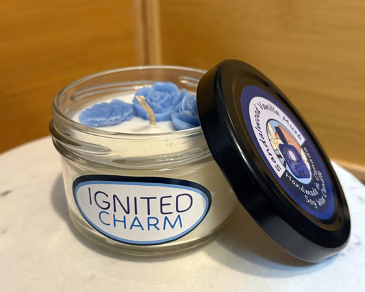 Candle in a glass jar with a decorative label on a marble surface